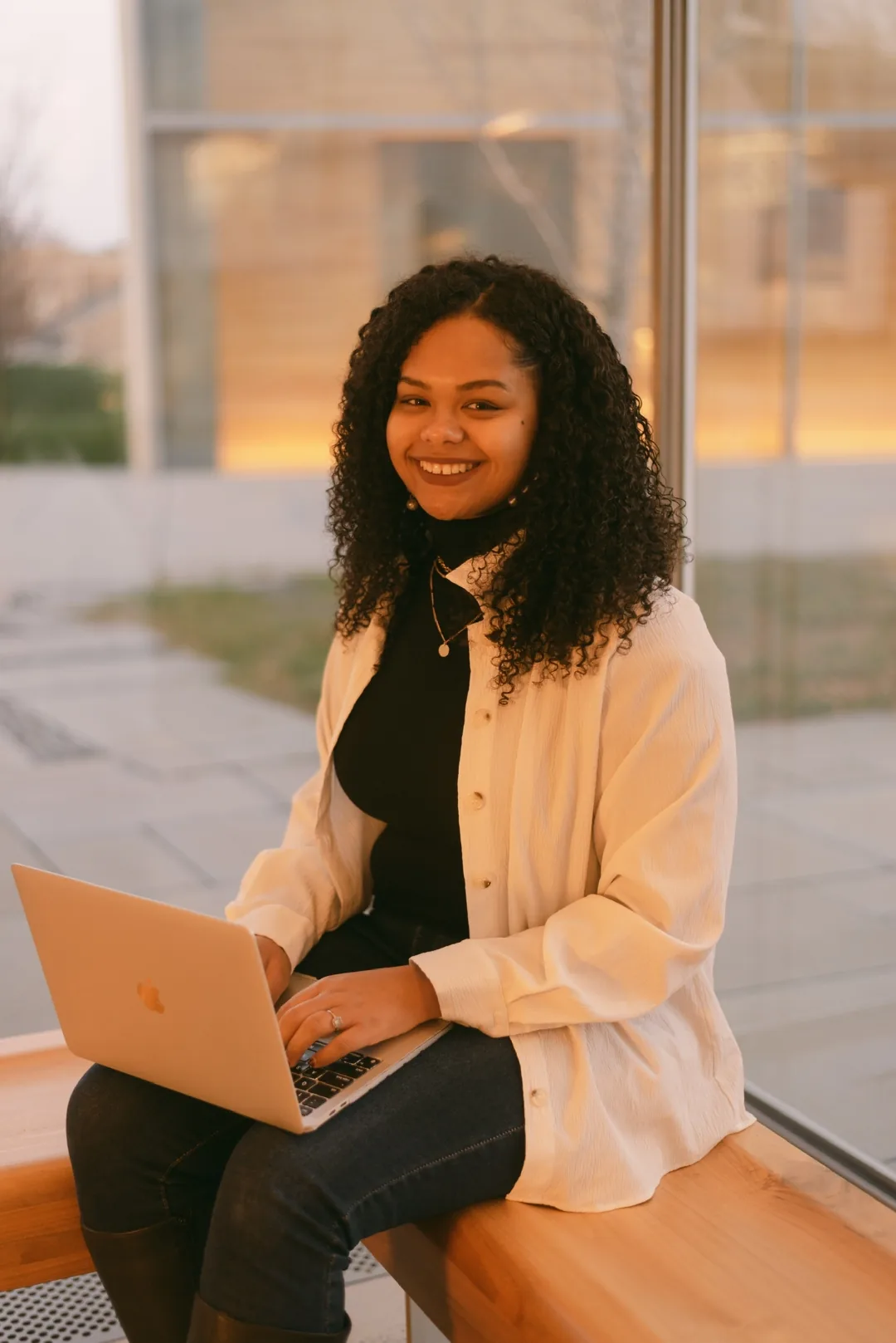 Nicole Olaniyi, founder of Lionheart Coaching Academy, seated with a laptop at golden hour.